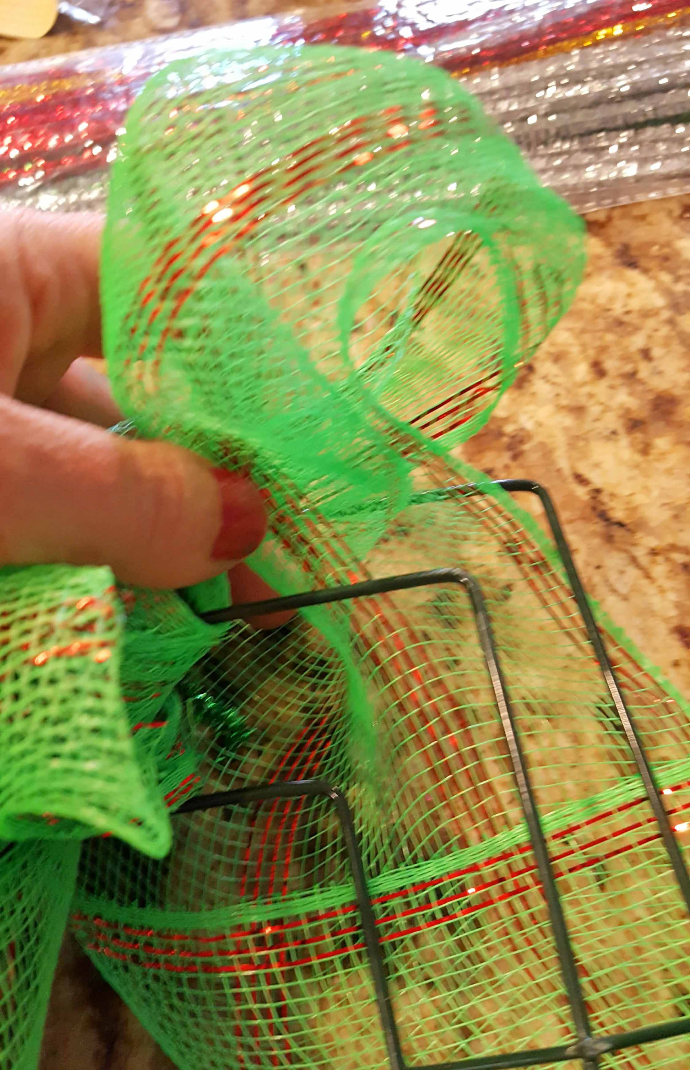 adding mesh ribbon to a grinch wreath